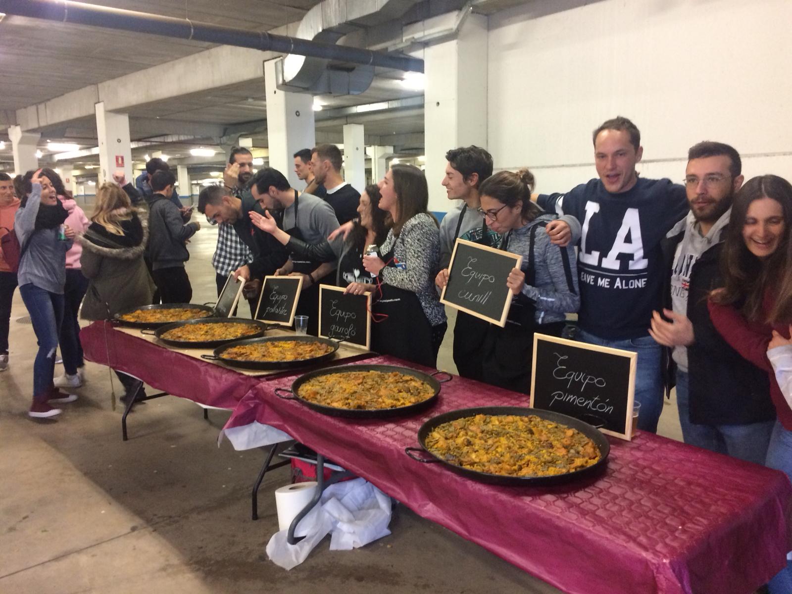 Paellas terminadas de varios equipos con sus pizarras durante un concurso de teambuilding